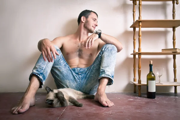 Porträt eines jungen Mannes, der auf dem Boden sitzt — Stockfoto