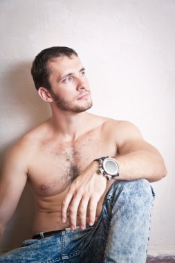 Duvarın yanında katta oturan genç çekici adam