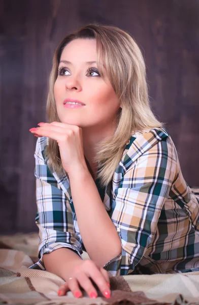 Portrait of a young attractive woman lying on plaid blanket, close-up — Stock Photo, Image