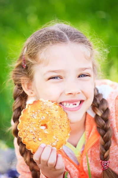 Dulce chica con un toth caído sosteniendo galletas en su mano —  Fotos de Stock