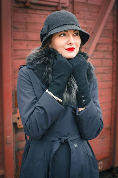 Portret van een vrouw in de jas en zwarte hoed — Stockfoto