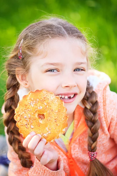 Lief meisje met een gevallen tand cookies met in haar hand — Stockfoto