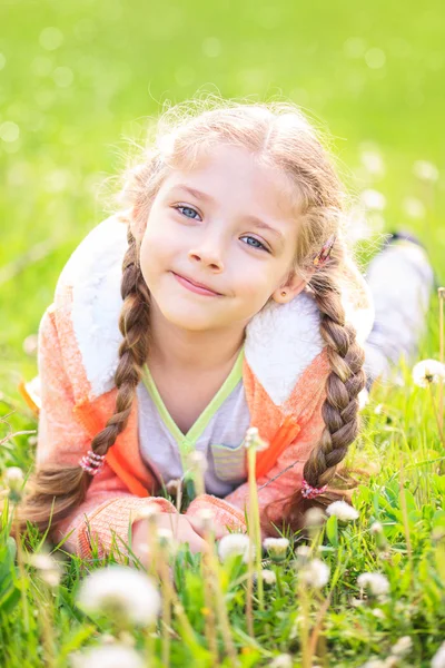 Söt liten flicka på ängen på sommardagen — Stockfoto