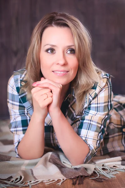 Portrait of a young attractive woman lying on plaid blanket, close-up — Stock Photo, Image