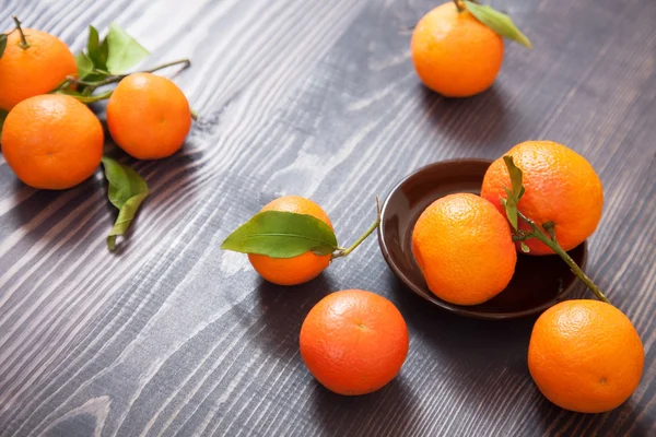 Várias tangerinas maduras em uma mesa de madeira — Fotografia de Stock