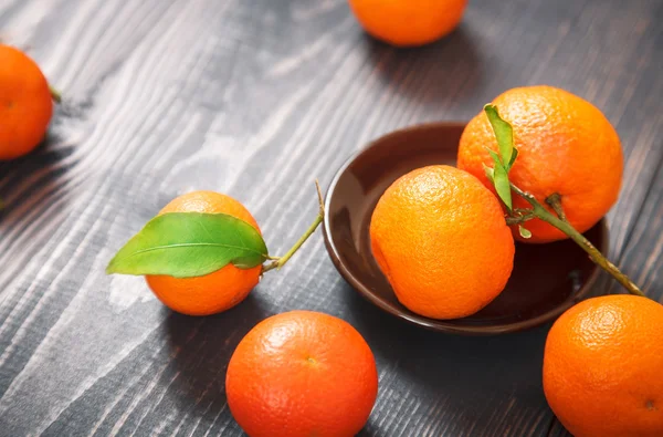 Várias tangerinas maduras em uma mesa de madeira — Fotografia de Stock