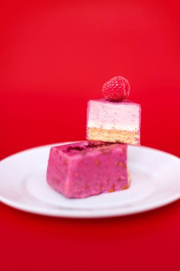 Kırmızı zemin üzerinde ahududu olan kremalı pasta, stüdyo fotoğrafı..