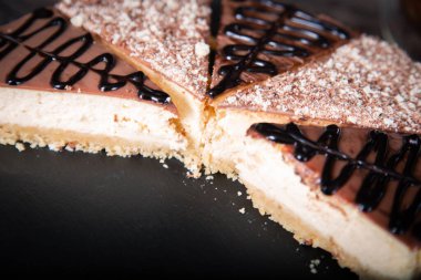 Masaya yakın planda kakao ve çikolata soslu dilimlenmiş peynirli kek..