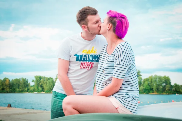 Homme et femme assis sur un bateau renversé — Photo