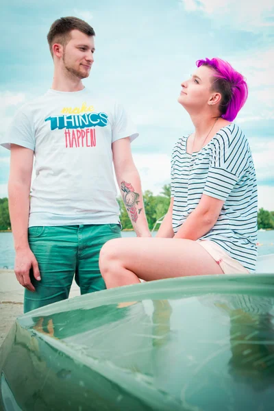 Man en vrouw zitten op een upturned boot — Stockfoto