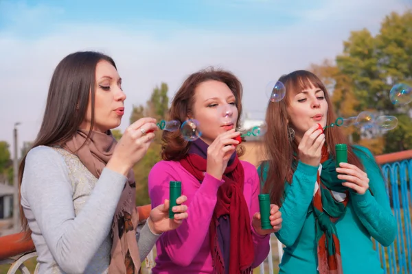 Três jovens mulheres bonitas soprar bolhas — Fotografia de Stock