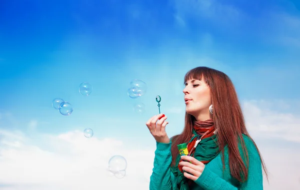 Beautiful brunette blowing bubbles — Stock Photo, Image