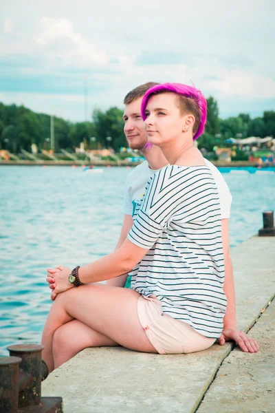 Man and woman sitting on the river bank — Stock Photo, Image