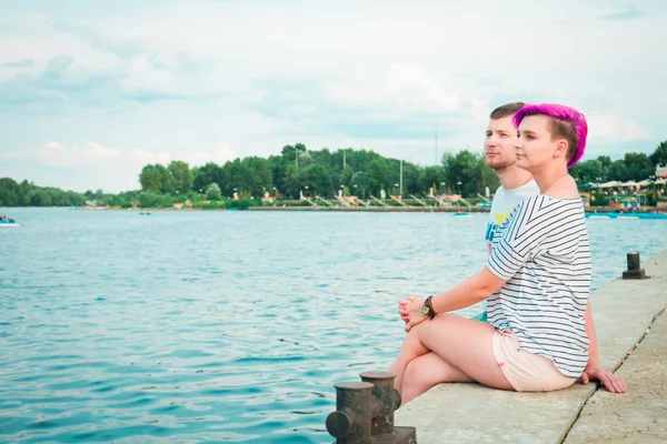 Hombre y mujer sentados en la orilla del río —  Fotos de Stock