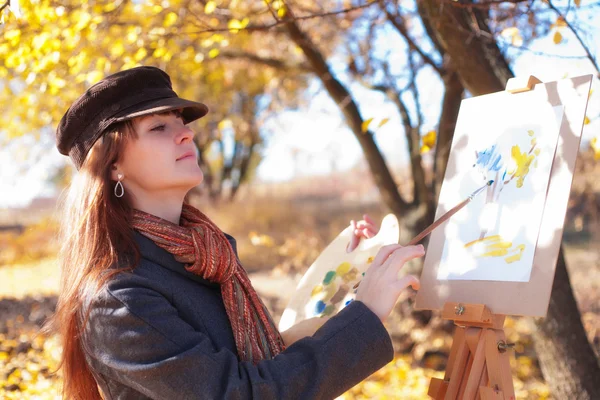 The girl draws on nature autumn