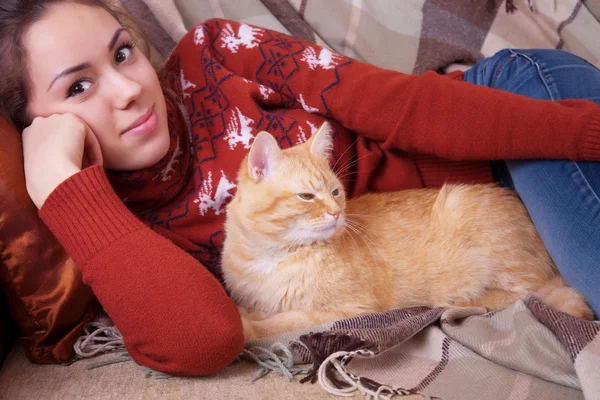 Giovane donna appoggiata sul divano con un gatto — Foto Stock