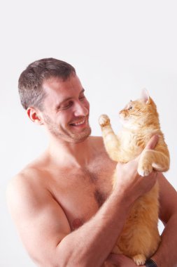 Bir kedi ellerinde tutan adam