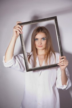 Bir çerçeve elinde tutan üzgün kadın