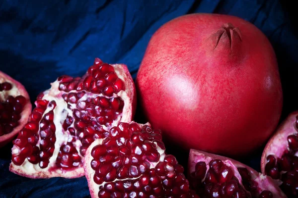 Šťavnatá zralá granátová jablka na tmavém pozadí — Stock fotografie