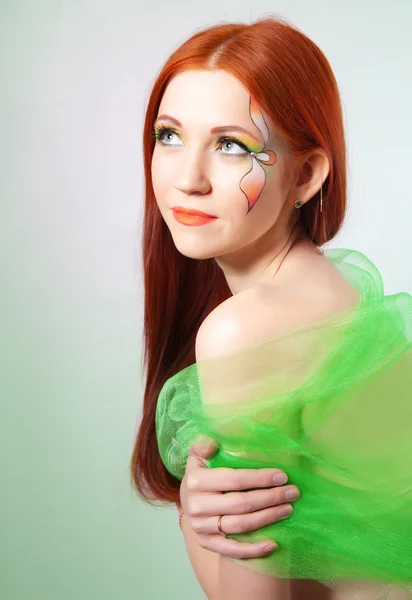 Retrato de una hermosa chica pelirroja con una flor pintada en su cara —  Fotos de Stock