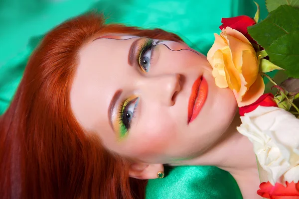 Portret van mooi roodharig meisje met bloemen — Stockfoto