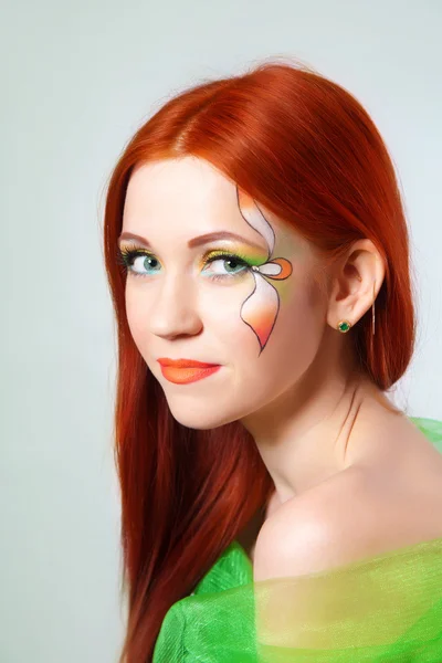 Retrato de una hermosa chica pelirroja con una flor pintada en su cara —  Fotos de Stock