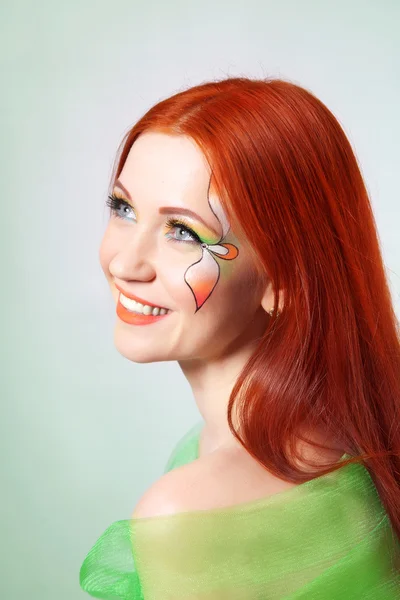 Retrato de una hermosa chica pelirroja con una flor pintada en su cara —  Fotos de Stock