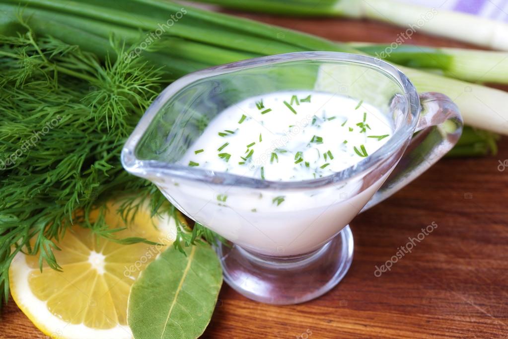 Creamy sauce with herbs on a table