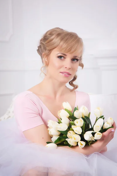 Mooie blonde vrouw met een boeket van tulpen — Stockfoto