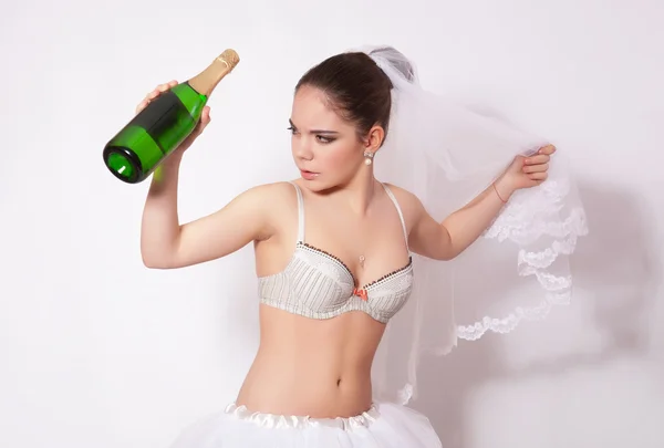 Sorgliga brud med en flaska champagne i handen — Stockfoto