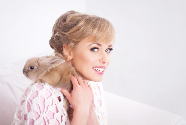 Jonge vrouw met een konijn in handen — Stockfoto