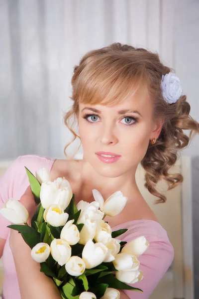 Mooie blonde vrouw met een boeket van tulpen — Stockfoto