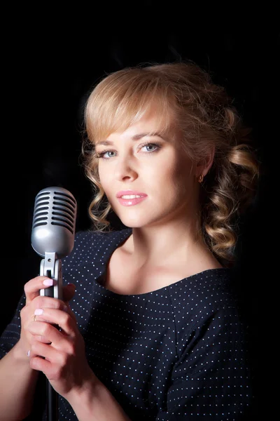Beautiful girl with a microphone on stage — Stock Photo, Image