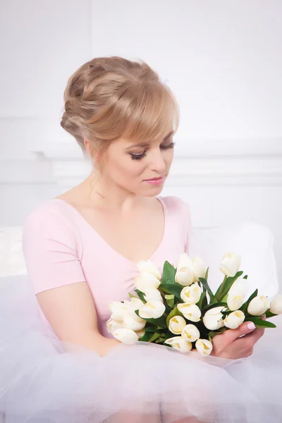 Schöne blonde Frau mit einem Strauß Tulpen — Stockfoto