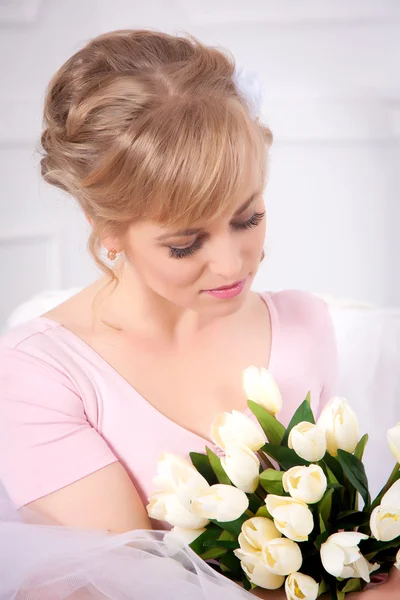 Schöne blonde Frau mit einem Strauß Tulpen — Stockfoto