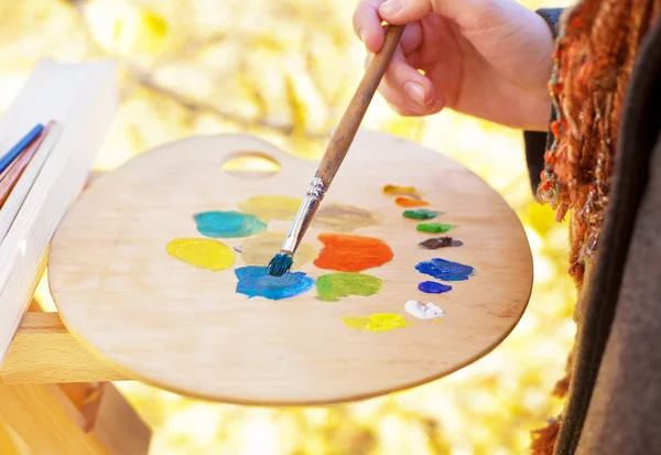 Художник смешивает краски разных цветов на палитре — стоковое фото