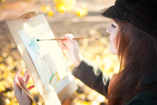 她手中的画笔与一个年轻美丽的女人的画像 — 图库照片