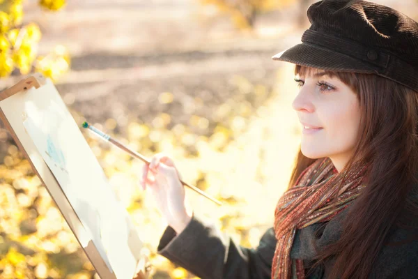 Porträtt av den unga vackra kvinnan med en pensel i handen — Stockfoto