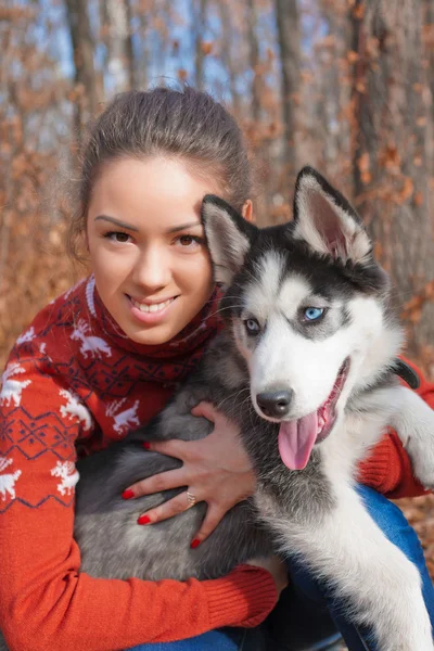 Hermosa joven mujer abrazando huskies cachorro para un paseo por el parque —  Fotos de Stock