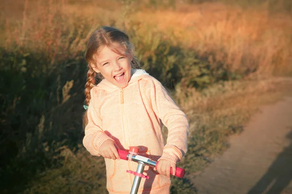 Bella ragazza guida scooter su strada rurale — Foto Stock