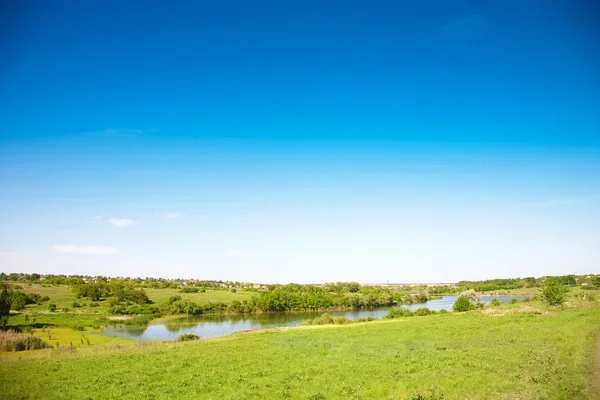 Pradera y valle con un estanque — Foto de Stock