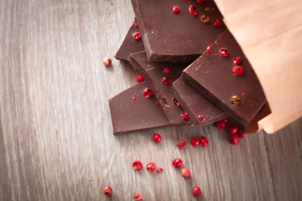 Bitar av mörk choklad med rosépeppar — Stockfoto