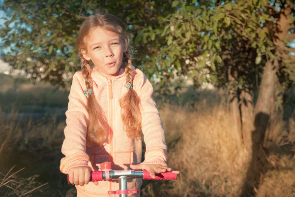 Девочка за рулем скутера на сельской дороге — стоковое фото