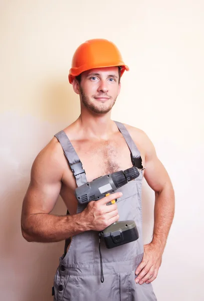 Man in overalls with a screwdriver — Stock Photo, Image