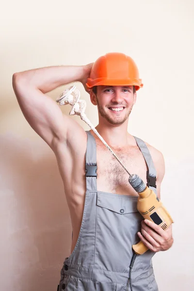 Man in overalls with a mixer for plastering — Stock Photo, Image