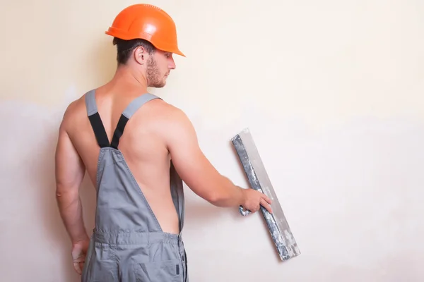Man in overalls with a large spatula — Stock Photo, Image