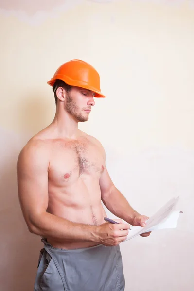 Man in a helmet writes on paper — Stock Photo, Image