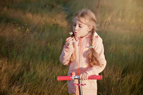 Dívka s koloběžkou na Pampeliška — Stock fotografie
