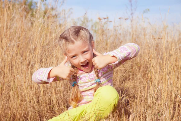 Radostná holčička na přírodu s zdvižený prst — Stock fotografie