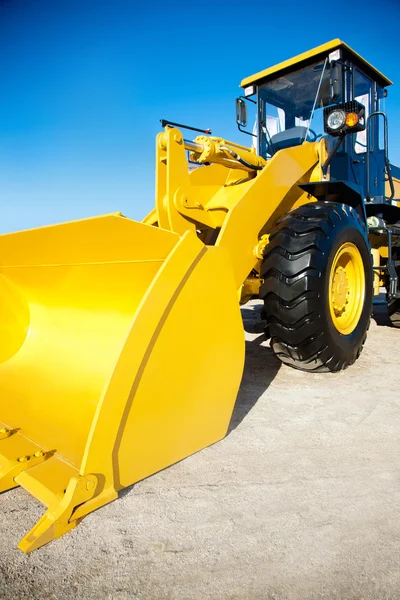 Leuchtend gelber Bagger vor blauem Himmel — Stockfoto